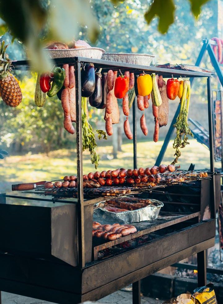 Grelha com linguiças, espetos, pimentões e abacaxi sobre a brasa
